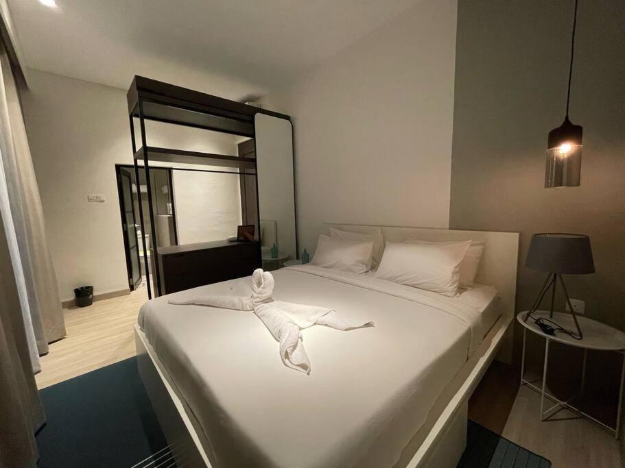 a bedroom with a bed with a white towel on it at Monde Residence H12 Batam Centre in Sengkuang