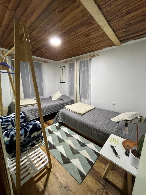 een kamer met twee bedden en een ladder erin bij Hostal waiwen in Matanzas