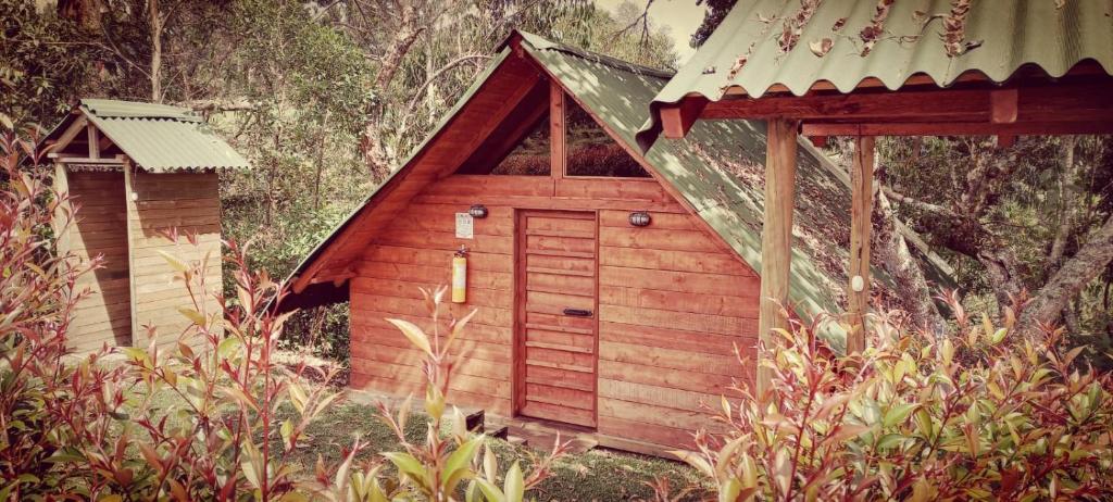 a small wooden dog house with a pitched roof at Sukha Glamping in Rionegro