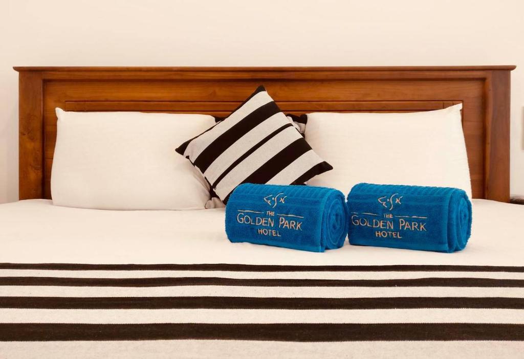 The Golden Park Hotel في أنورادابورا: سرير عليه وسادتين زرقاوين