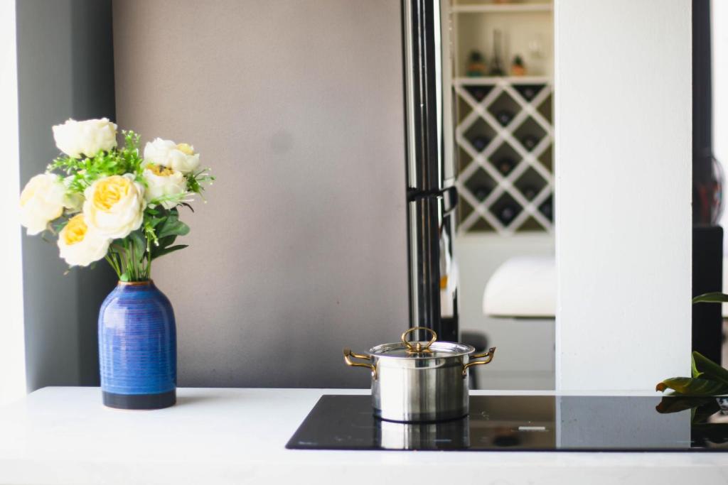 a blue vase with white flowers on a counter at Green Line Long Bien - Serviced Apartment - Ngoc Thuy - Hanoi in Hanoi