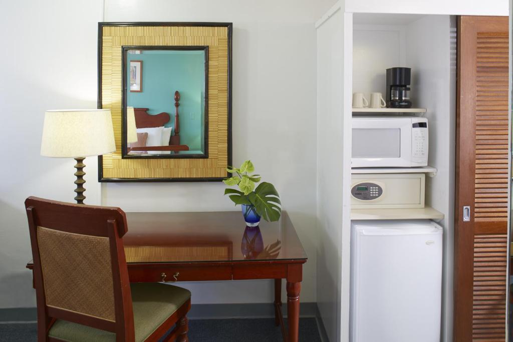 a room with a desk with a microwave and a mirror at Pagoda Hotel in Honolulu