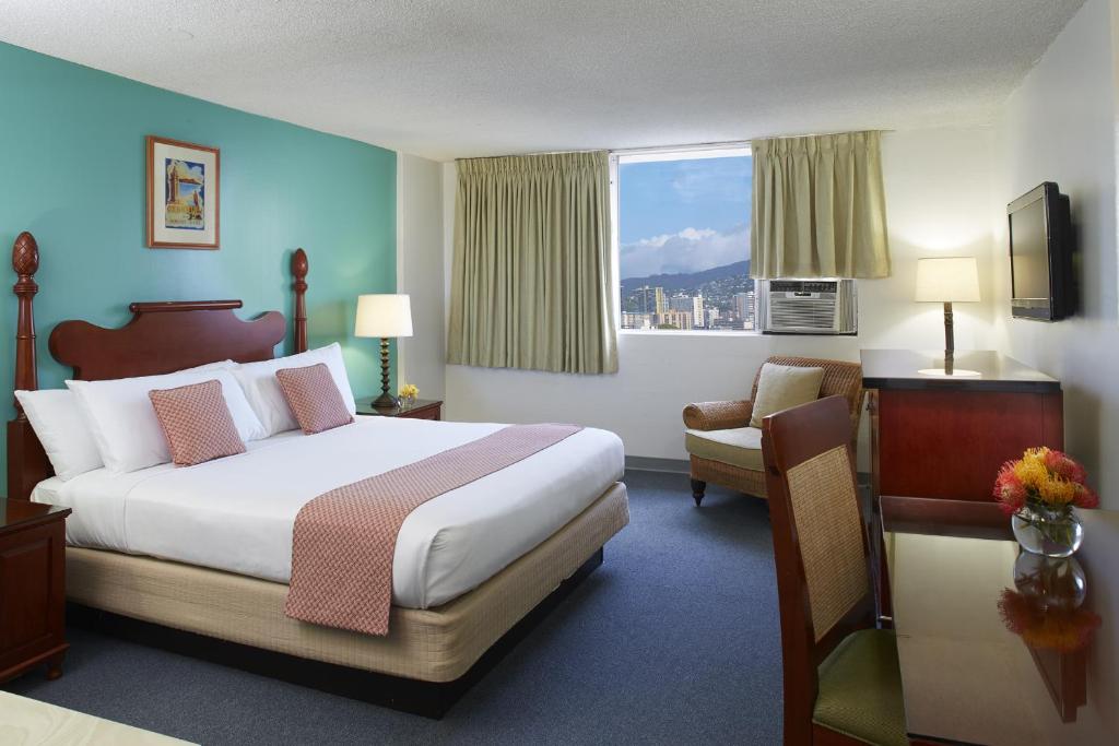 a hotel room with a bed and a chair at Pagoda Hotel in Honolulu