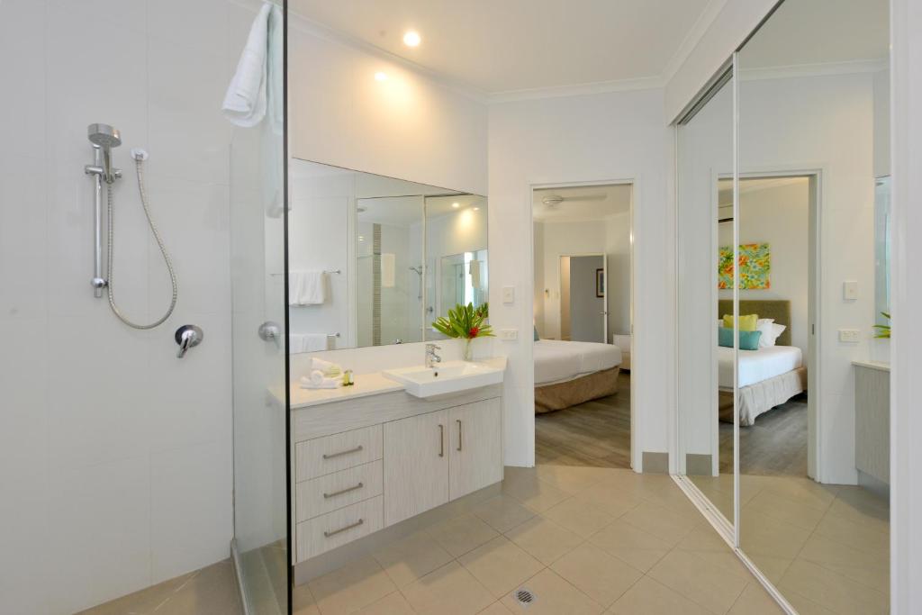 a white bathroom with a sink and a shower at Beaches Holiday Apartments with Onsite Reception & Check In in Port Douglas