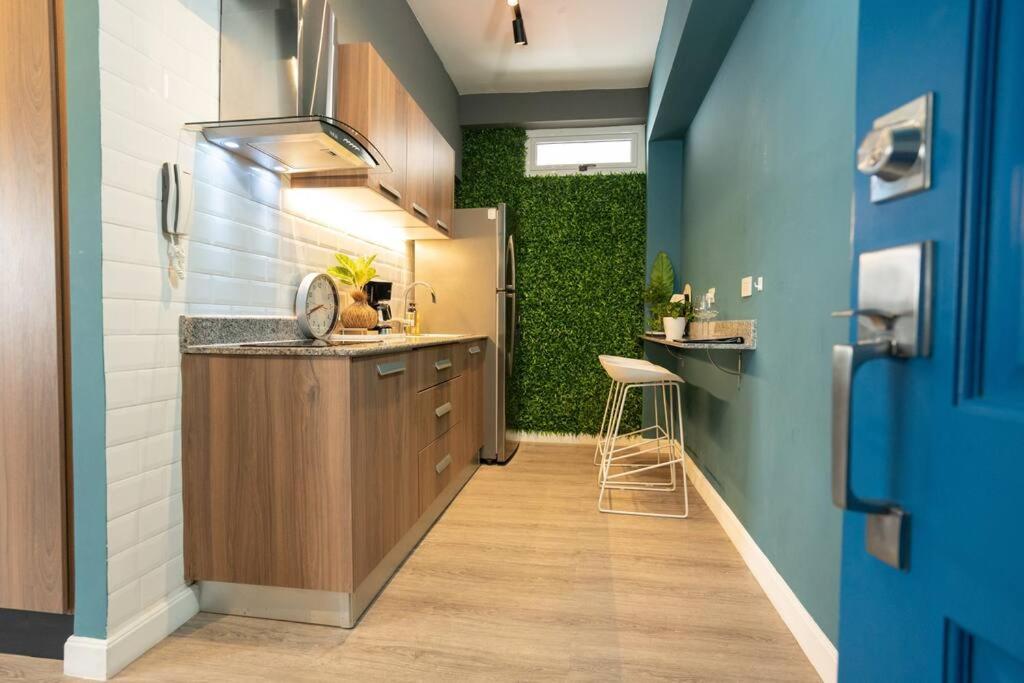 a kitchen with a counter and a green wall at Apartamento Moderno Panamá 02 in Panama City