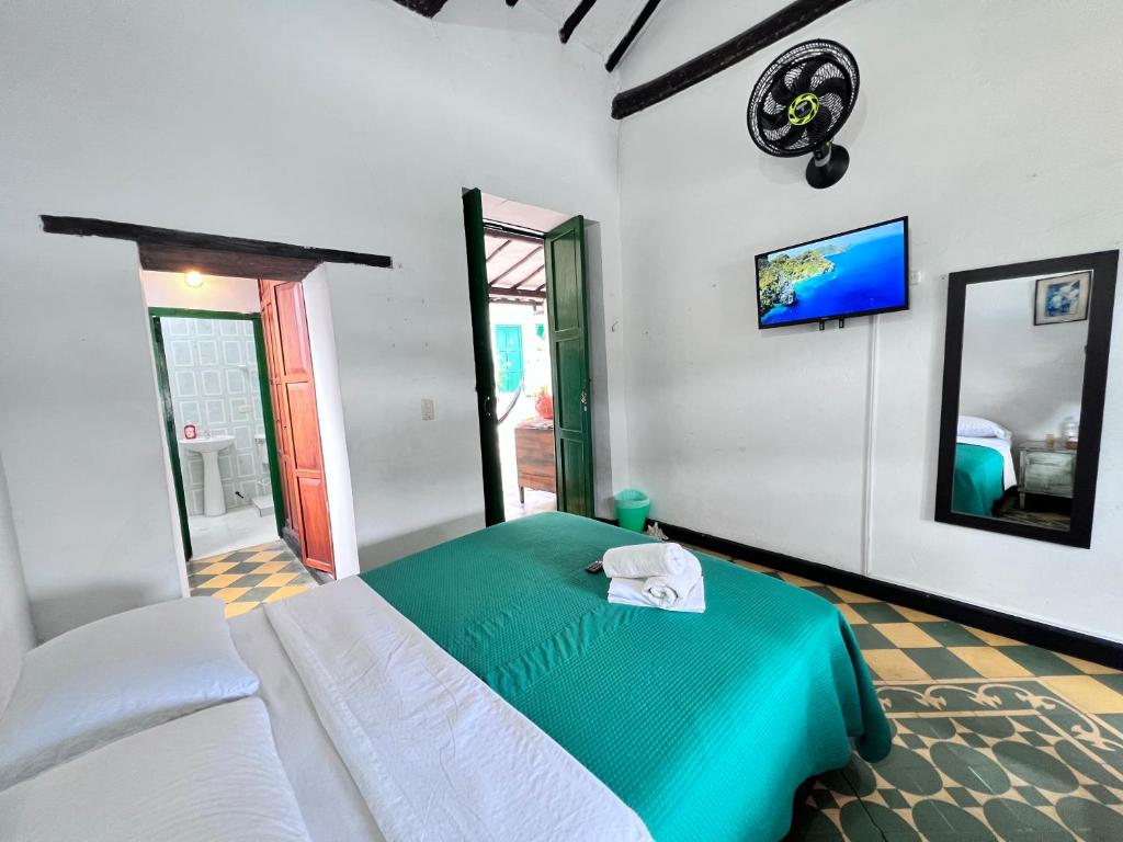 ein Schlafzimmer mit einem Bett und einem TV an der Wand in der Unterkunft Green Door San Gil in San Gil