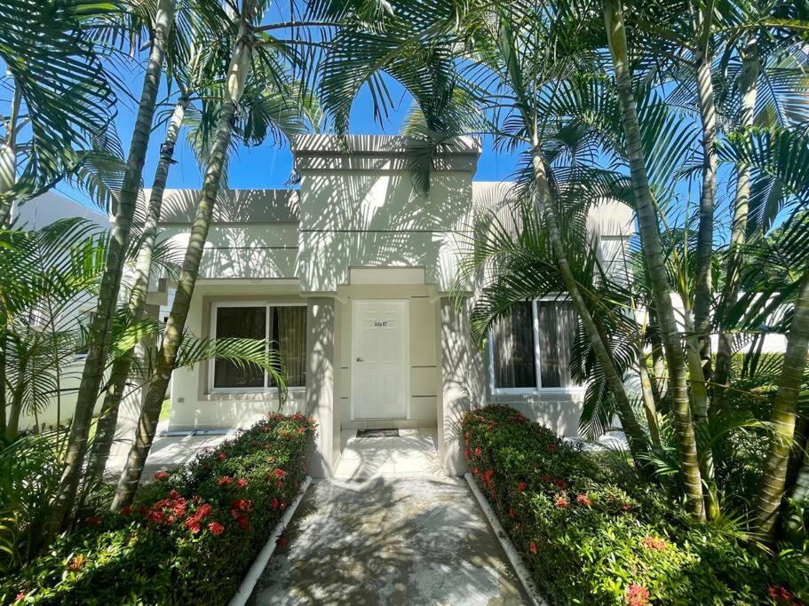 Biały dom z palmami przed nim w obiekcie Hermosa villa en Palma Real w mieście La Ceiba