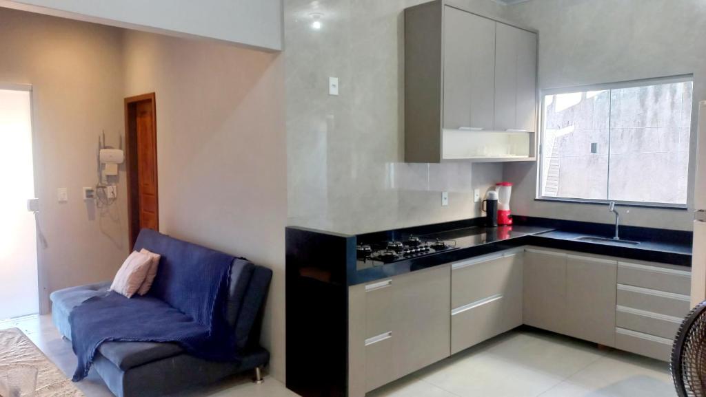 una cocina con fogones y una silla azul. en Casa confortável 3 quartos, en Carolina