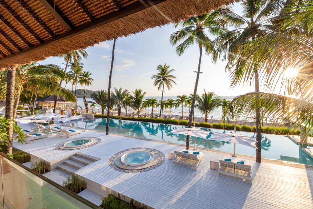 uma imagem de uma piscina de resort com palmeiras em Seven Secrets by Hanging Gardens em Senggigi