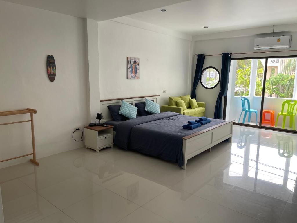 1 dormitorio con 1 cama y 1 silla amarilla en Skipper's Karon, en Karon Beach