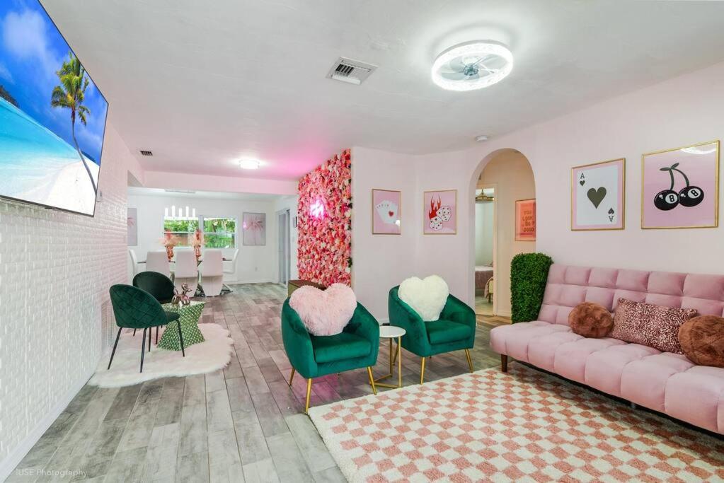 een woonkamer met een roze bank en groene stoelen bij Pretty in Pink - Pool - Vanity Area - Coffee Nook in Fort Lauderdale