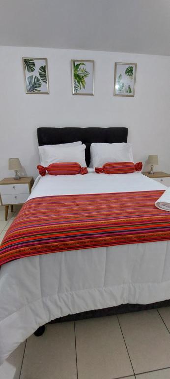 een slaapkamer met een groot bed met rode kussens bij C&G Home Perú in Lima