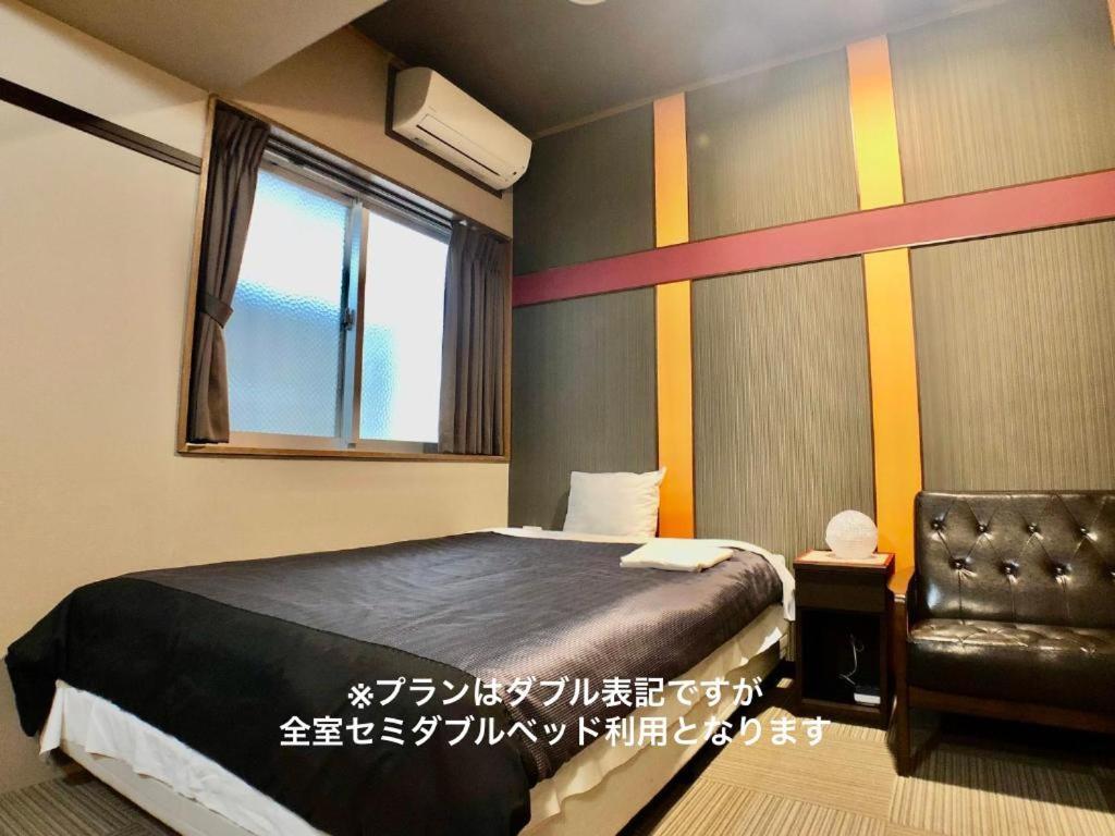 a bedroom with a bed and a chair and a window at Time Rich in Okinawa City