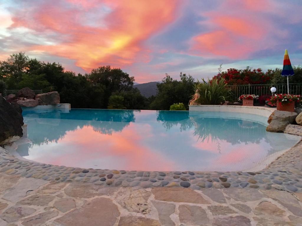 uma piscina com um arco-íris no céu em Un petit paradis en Provence em Fréjus