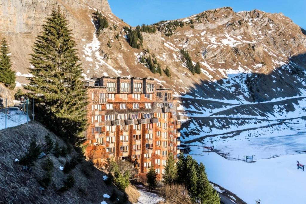 un bâtiment sur le flanc d'une montagne dans la neige dans l'établissement Résidence quartier Hauts-Forts - maeva Home - Studio 2 Personnes Confort - La Pointe de Vorlaz MAE-4215, à Morzine