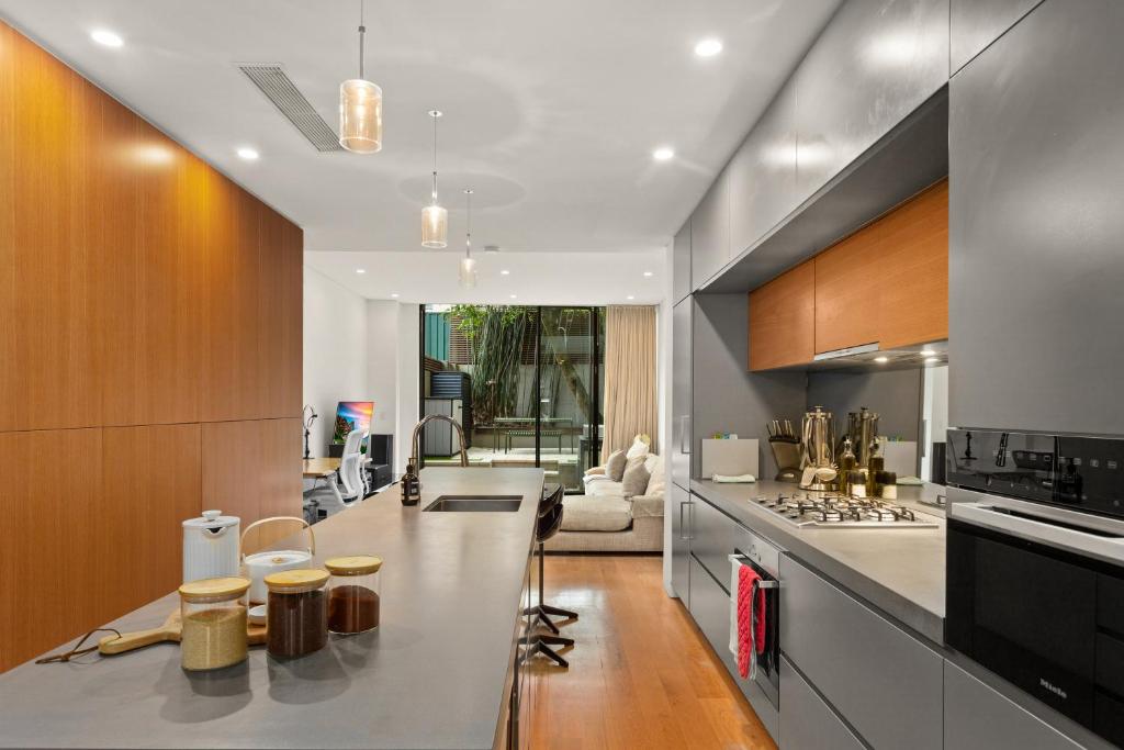 een keuken met een aanrecht en een fornuis top oven bij Modern, Elegant Oasis - Trendy Area - Free Parking in Sydney