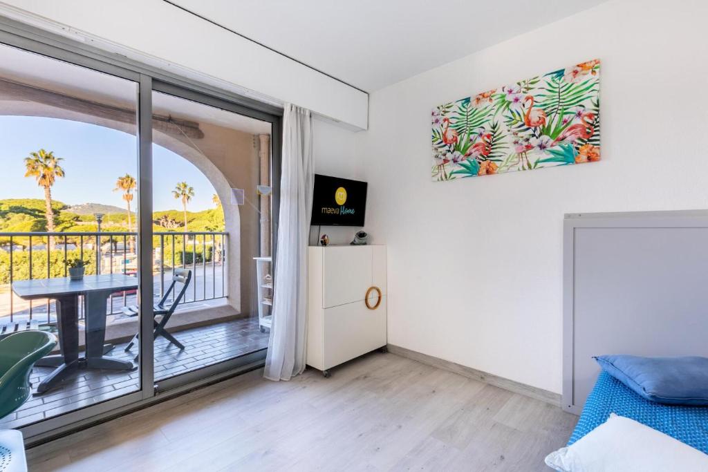 d'un salon avec une table et un balcon. dans l'établissement Hyeres Parc - maeva Home - Studio 4 personnes Sélection MAE-6606, à Hyères