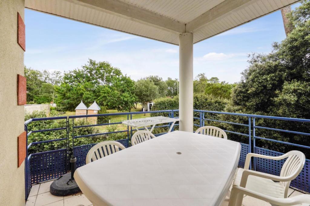 un patio avec une table et des chaises blanches sur un balcon dans l'établissement Résidence Villa Marine - maeva Home - Appartement 3 Pièces 6 Personnes - Sélection MAE-2656, à Soulac-sur-Mer