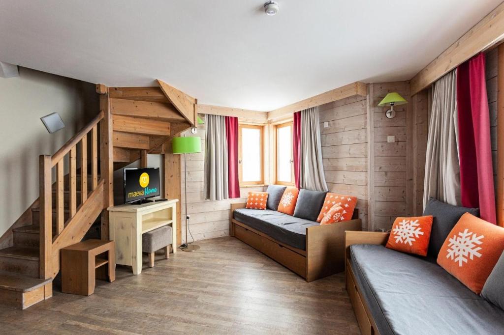 a small living room with a couch and a tv at Résidence Le Christiana - maeva Home - Appartement Duplex 3 Pièces 10 Personnes - Sélection MAE-3643 in Saint-Bon-Tarentaise