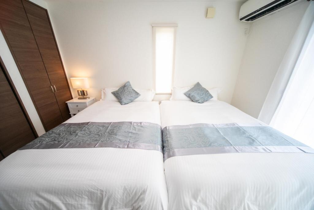 een slaapkamer met twee bedden en een raam bij Awaji Riverside Terrace in Shizuki 780 in Shizuki