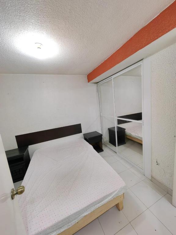 a small bedroom with a bed and a mirror at Departamento Amueblado Parque Toluca 2000 in Santín