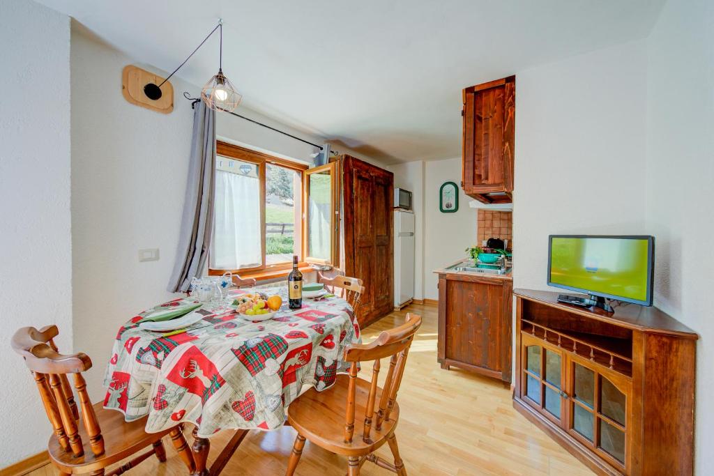 a dining room with a table and a television at Studio Clotes Ski In - Ski Out - Happy Rentals in Sauze dʼOulx