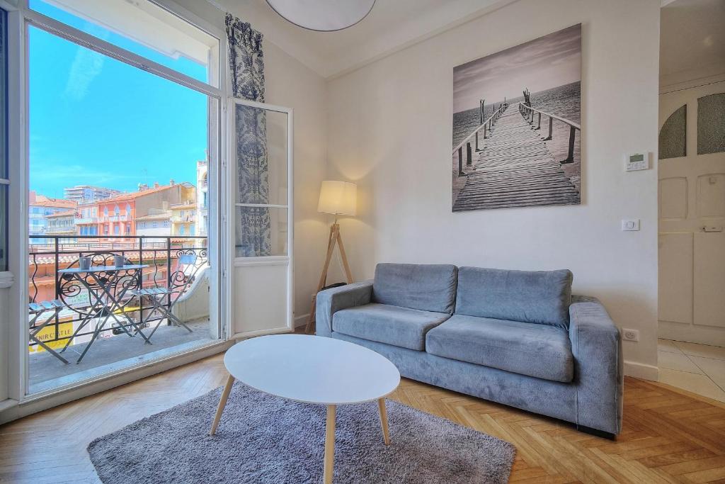 un salon avec un canapé, une table et une fenêtre dans l'établissement IMMOGROOM - Palais des festivals within walking distance - balcony - wifi -, à Cannes