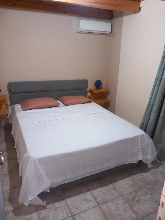 ein Schlafzimmer mit einem großen weißen Bett in einem Zimmer in der Unterkunft Alex 2 Bedroom Apartment in Planos
