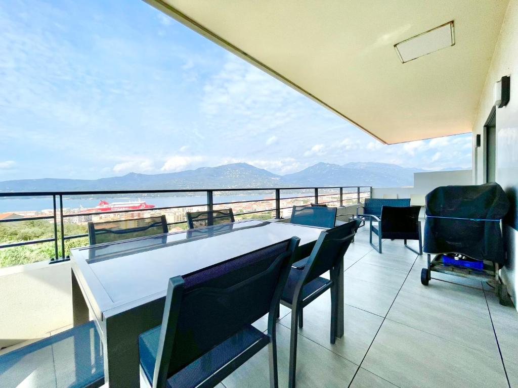 d'un balcon avec une table et des chaises et une vue. dans l'établissement VUE MER 180°, TERRASSE, CLIM, à Propriano