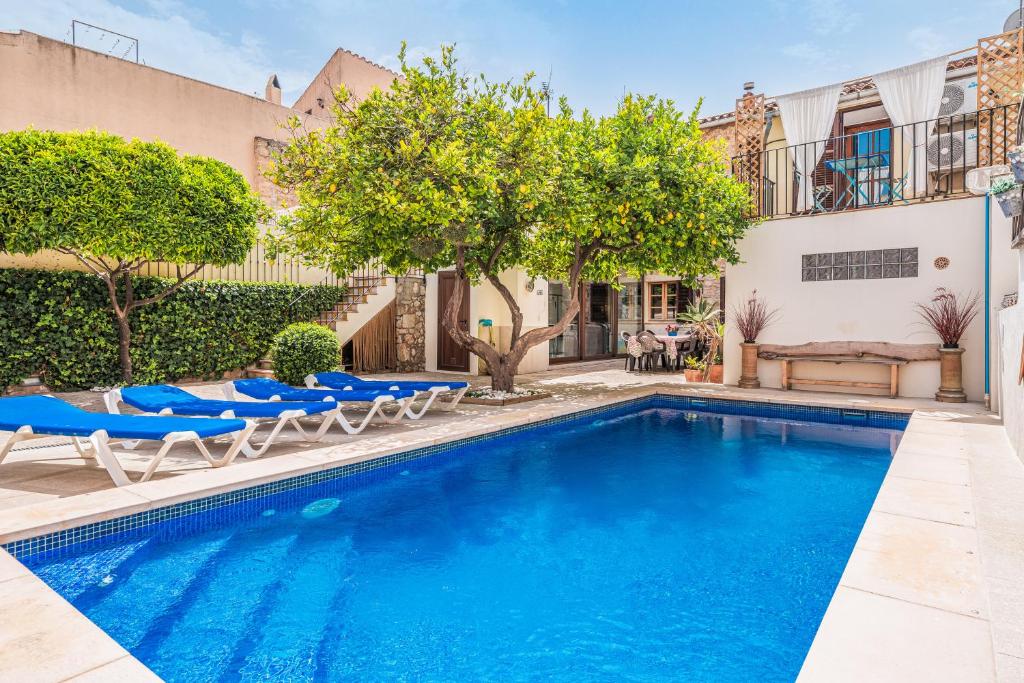 a swimming pool with blue chairs and a house at Sa Llimonera de Binissalem in Binissalem