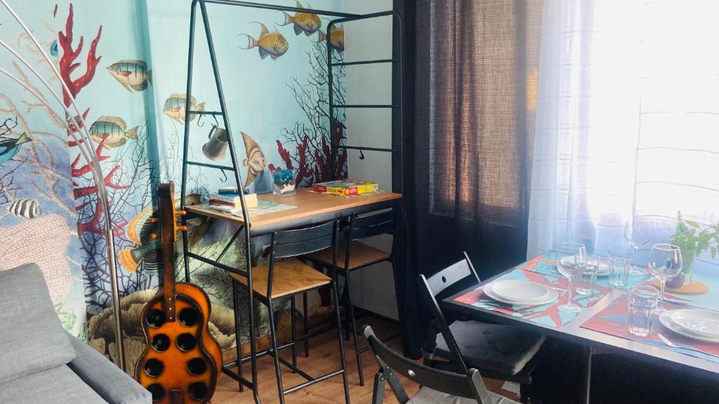 une chambre avec une table et une guitare à côté d'une table avec table dans l'établissement бутиков апартамент Деси, à Pomorie