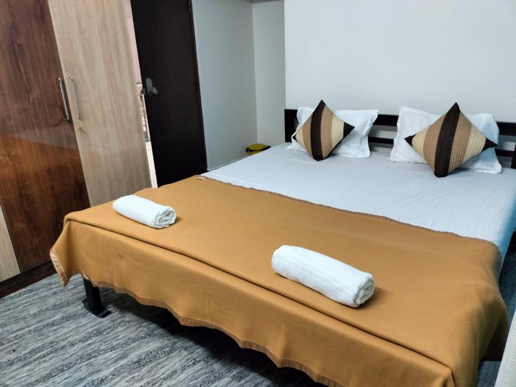 a hotel room with a bed with two towels on it at "SMS" HOME STAy in Kushālnagar