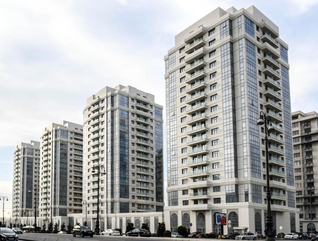 zwei hohe Gebäude in einer Stadt mit Autos in der Unterkunft Sport Plaza Hotel & Apartments in Baku