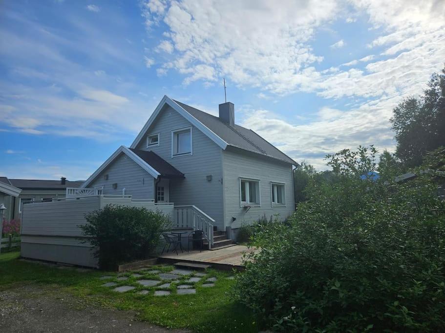 uma grande casa branca com uma cerca no quintal em Trivelig hus sentralt på Storslett em Storslett