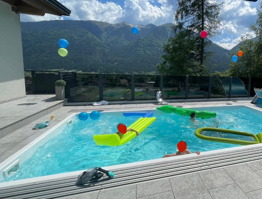 una piscina con dos niños jugando en el agua en Villa Stefaner, en Kirchbach