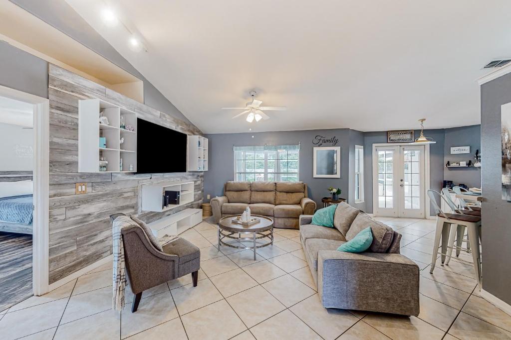 a living room with a couch and a tv at Sunkissed in Kissimmee in Kissimmee