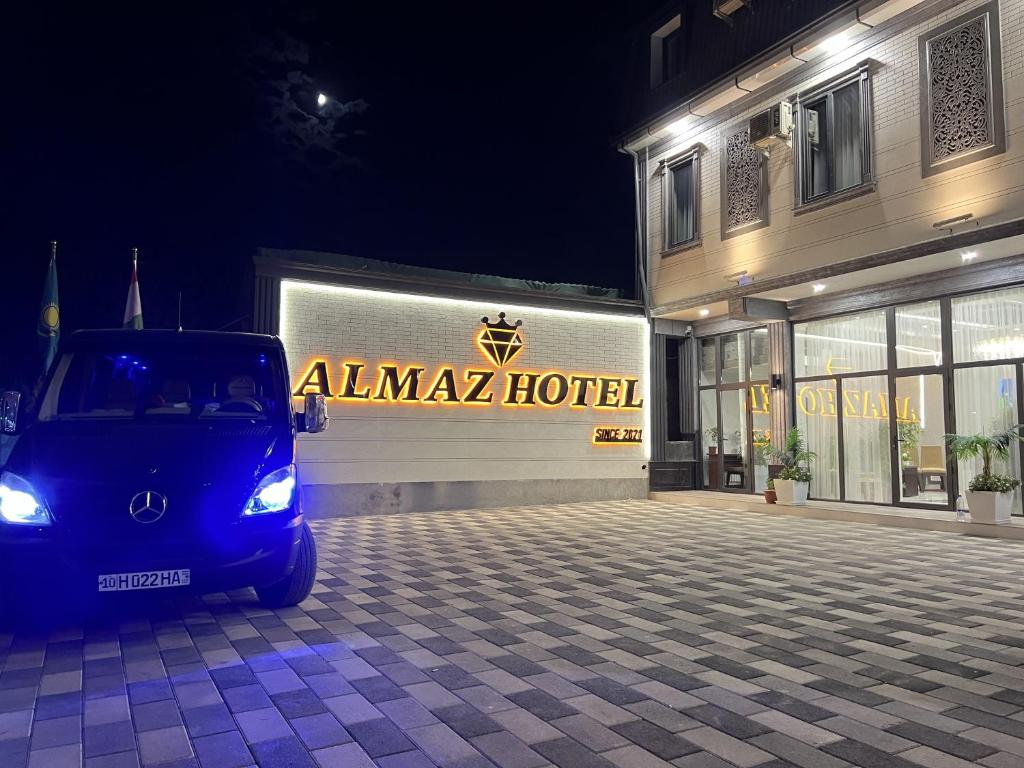 een kleine auto geparkeerd voor een gebouw bij Almaz Hotel Uzbekistan in Tasjkent