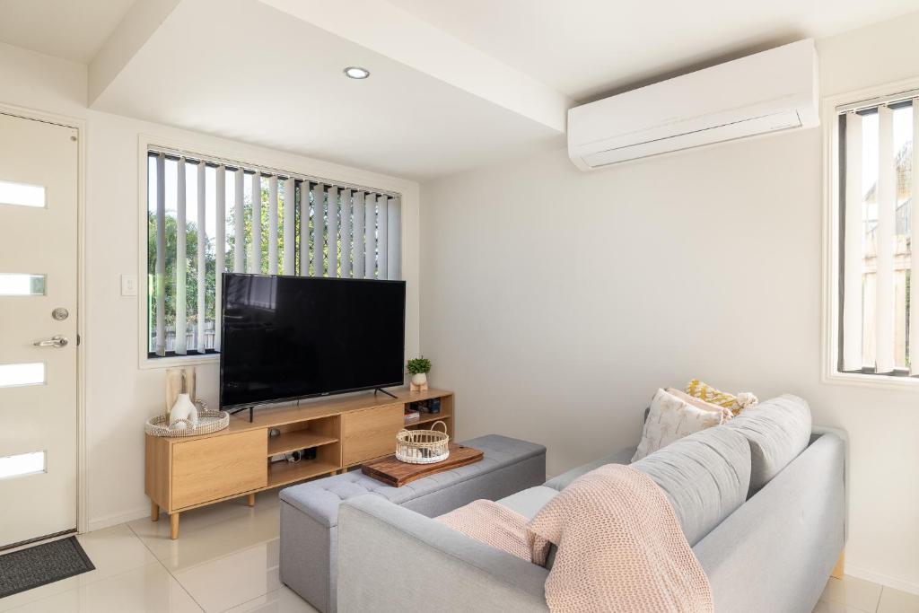 a living room with a couch and a flat screen tv at 2 Bedroom! Great Location & Walk to Train in Brisbane