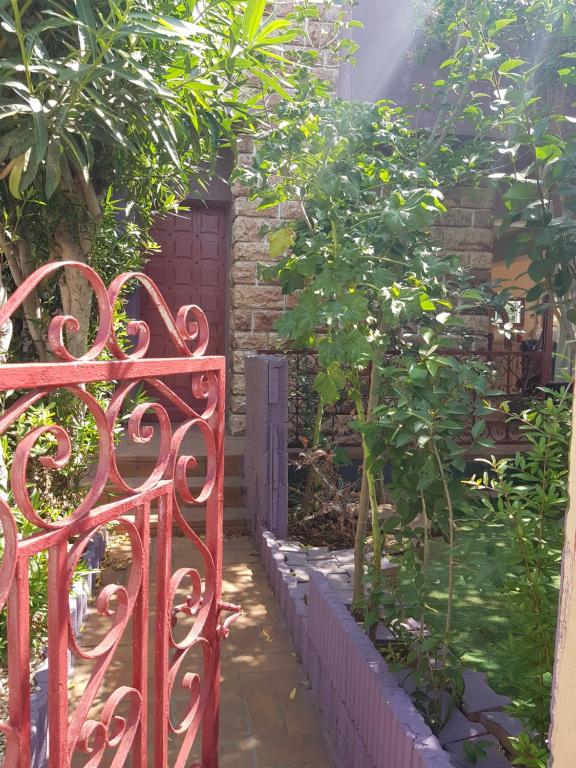 a red gate in front of a garden at "Maison Fi" à Valras, mer et centre à 2 pas, chambres privées, parties communes-commodités maison-jardin à dispo in Valras-Plage