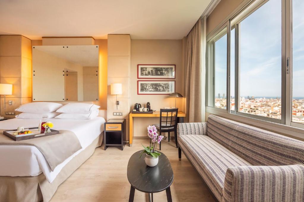 a hotel room with a bed and a couch at Hesperia Barcelona Presidente in Barcelona