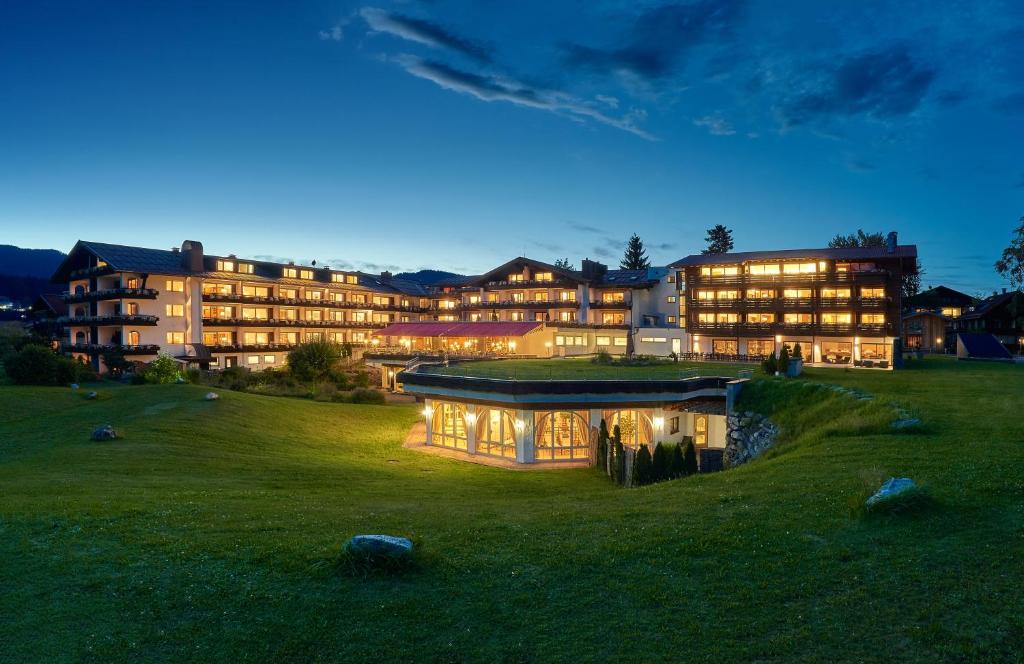 Un grand bâtiment est éclairé la nuit. dans l'établissement Schüle's Wellnessresort & SPA Adults Only, à Oberstdorf