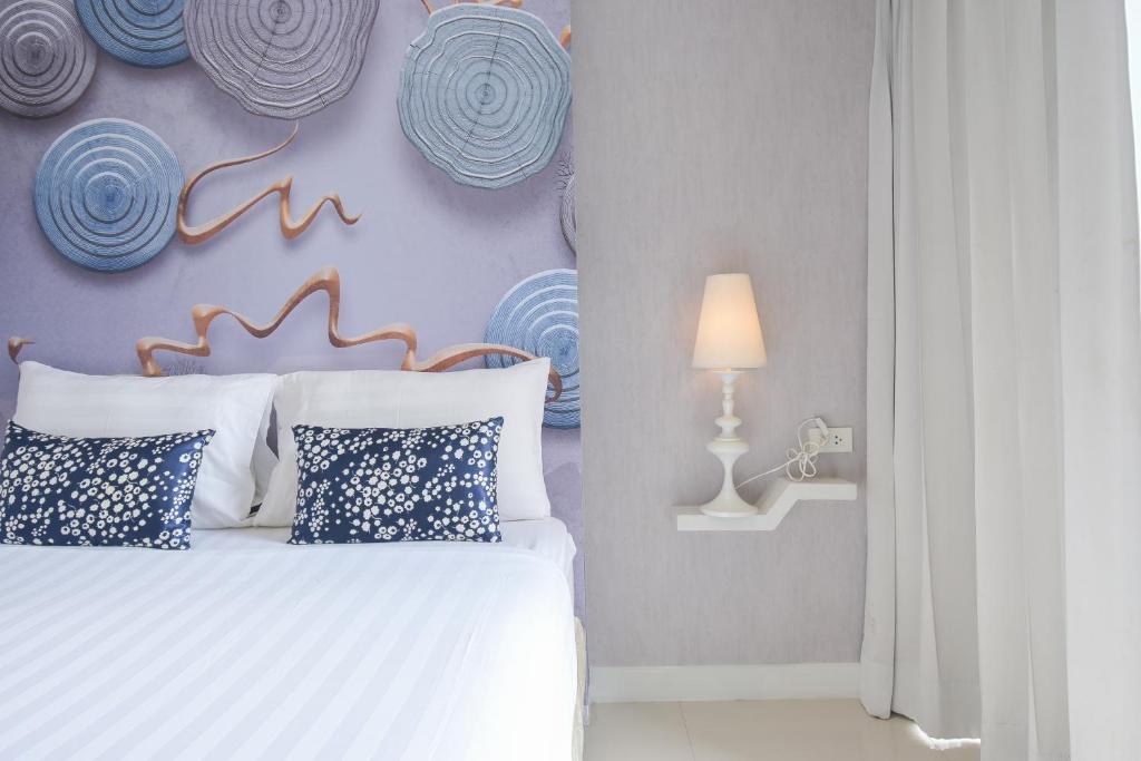 1 dormitorio con 1 cama con almohadas azules y blancas en Sino Maison, en Patong Beach