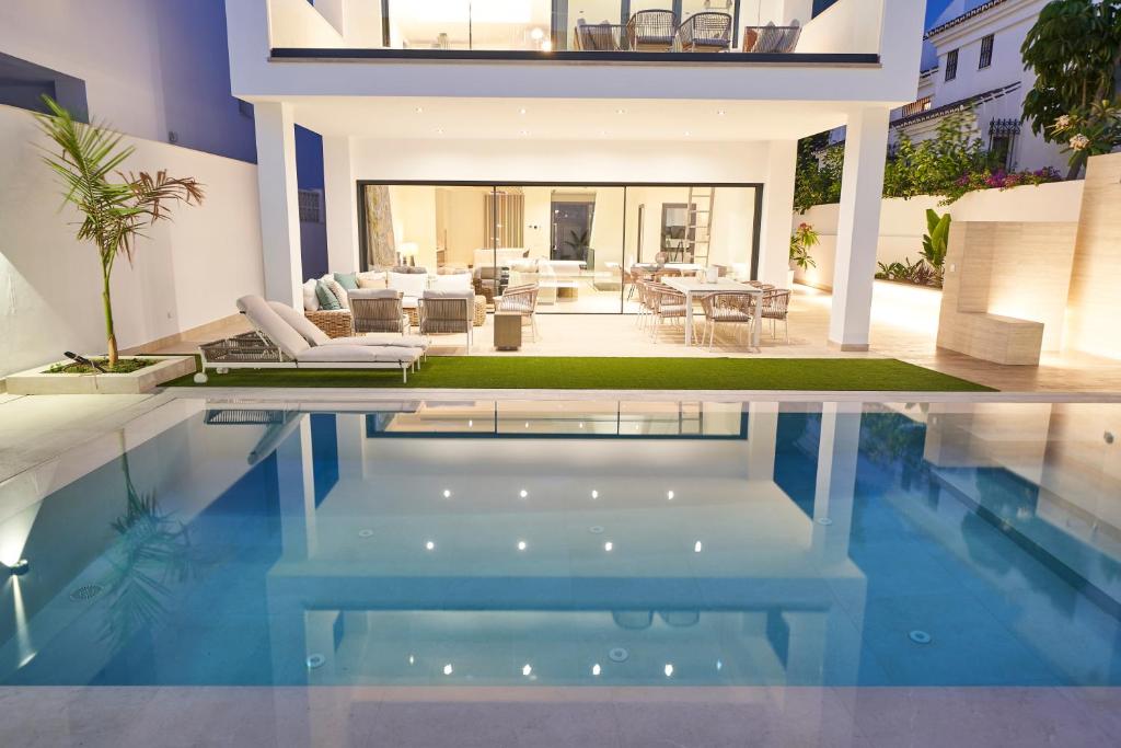 una casa con piscina frente a una casa en Villa Cristina, en Nerja