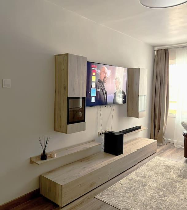 uma sala de estar com uma televisão de ecrã plano na parede em Refurnished Apartment in Rucava em Rucava