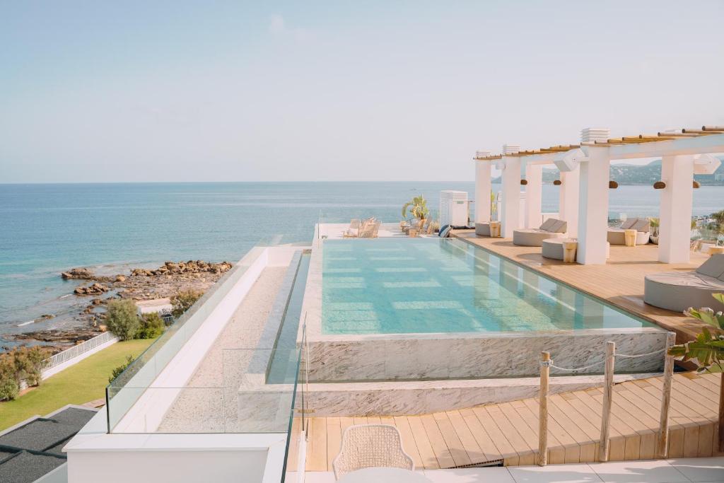 a swimming pool with the ocean in the background at Can Salia in San Antonio Bay