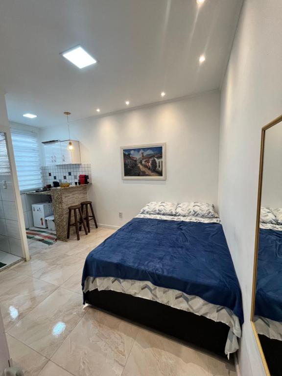 um quarto com uma cama azul e uma cozinha em Apartamento Moderno no Rio de Janeiro