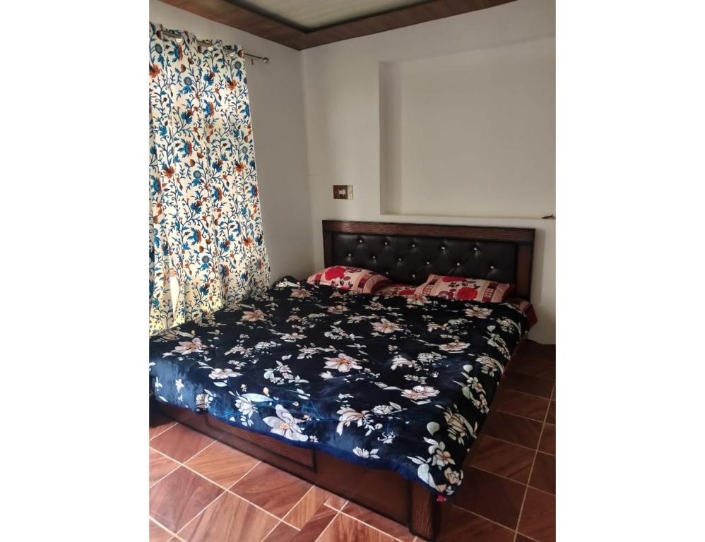 - une chambre avec un lit et un rideau dans l'établissement Ikhlas guest house, Srinagar, à Srinagar