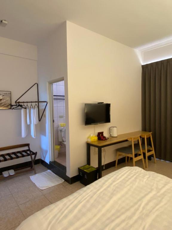 金城鎮的住宿－三坵民宿，一间卧室配有一张床、一张书桌和一台电视