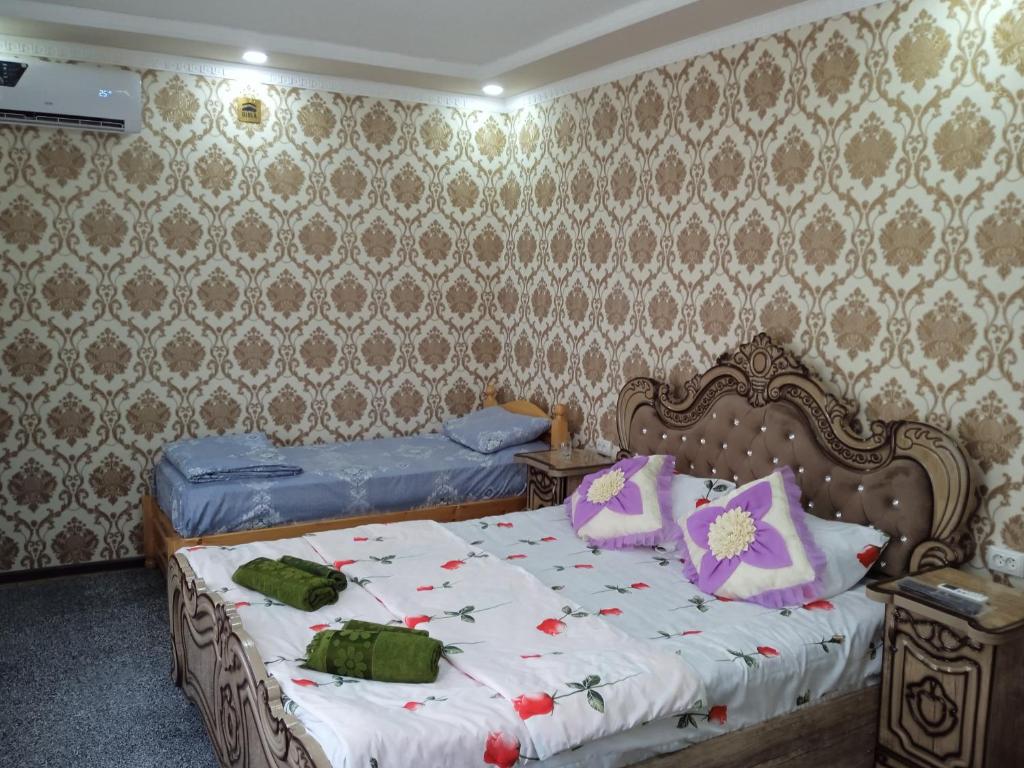 a bedroom with two beds and a wall at Guest House "AN" & Teahouse in Bukhara