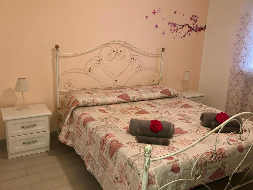 a bedroom with a bed with two red roses on it at Residenza San Michele in Tropea